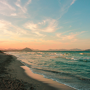 Golden-sand cove in Majorca with turquoise water at sunset